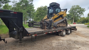 Dozer with land clearing  equipment sitting on track loader