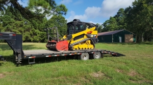 Bulldozer with mulching head sitting on track loader