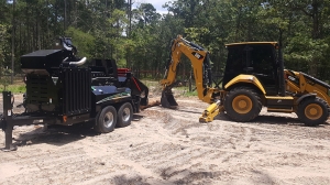 Tree chipper and backhoe