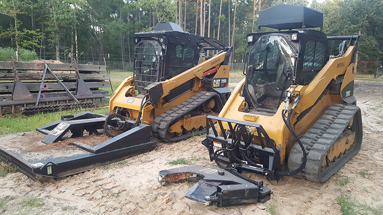 Compact track loader with Dymax tree shear - cuts trees flushed to the ground